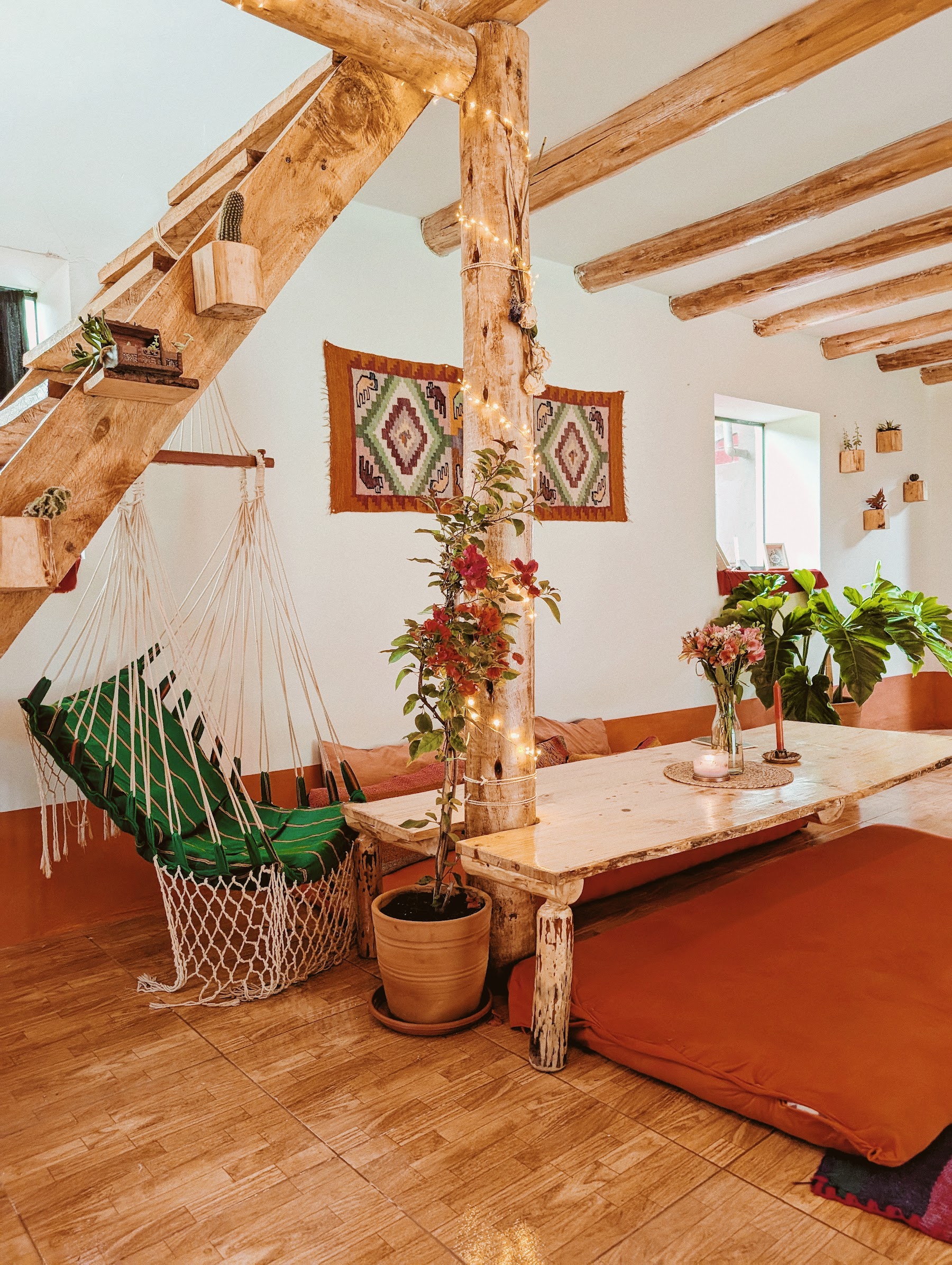 Sunlight, flowers and a woven hanging chair inside the River House