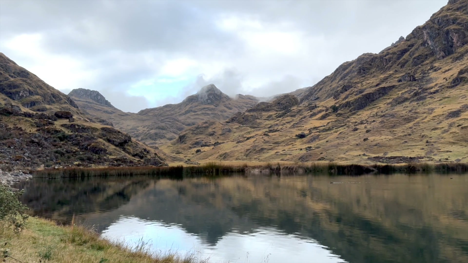 Clouds reflected in a still Andean mountain lake